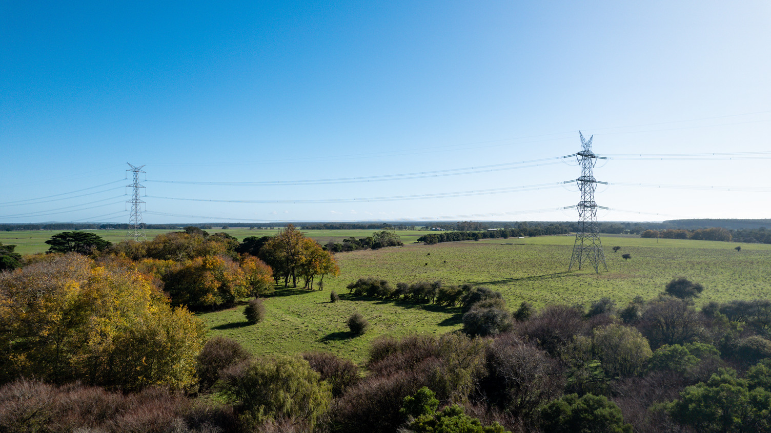 Two transmission towers spanning across a field