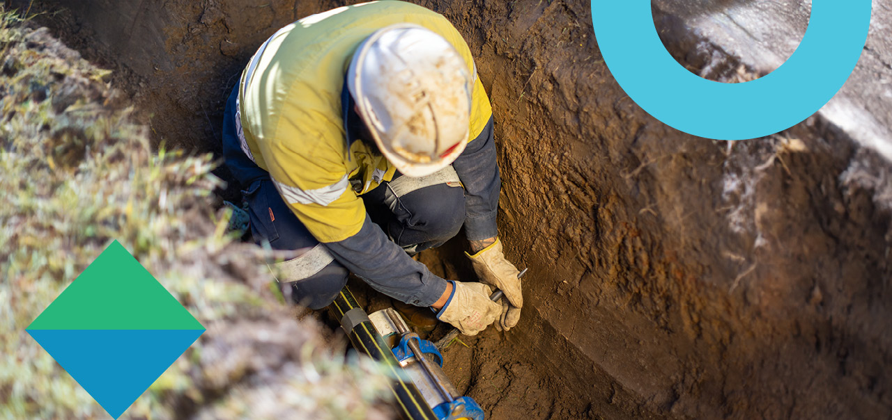 A man working on gas pipes in a trench