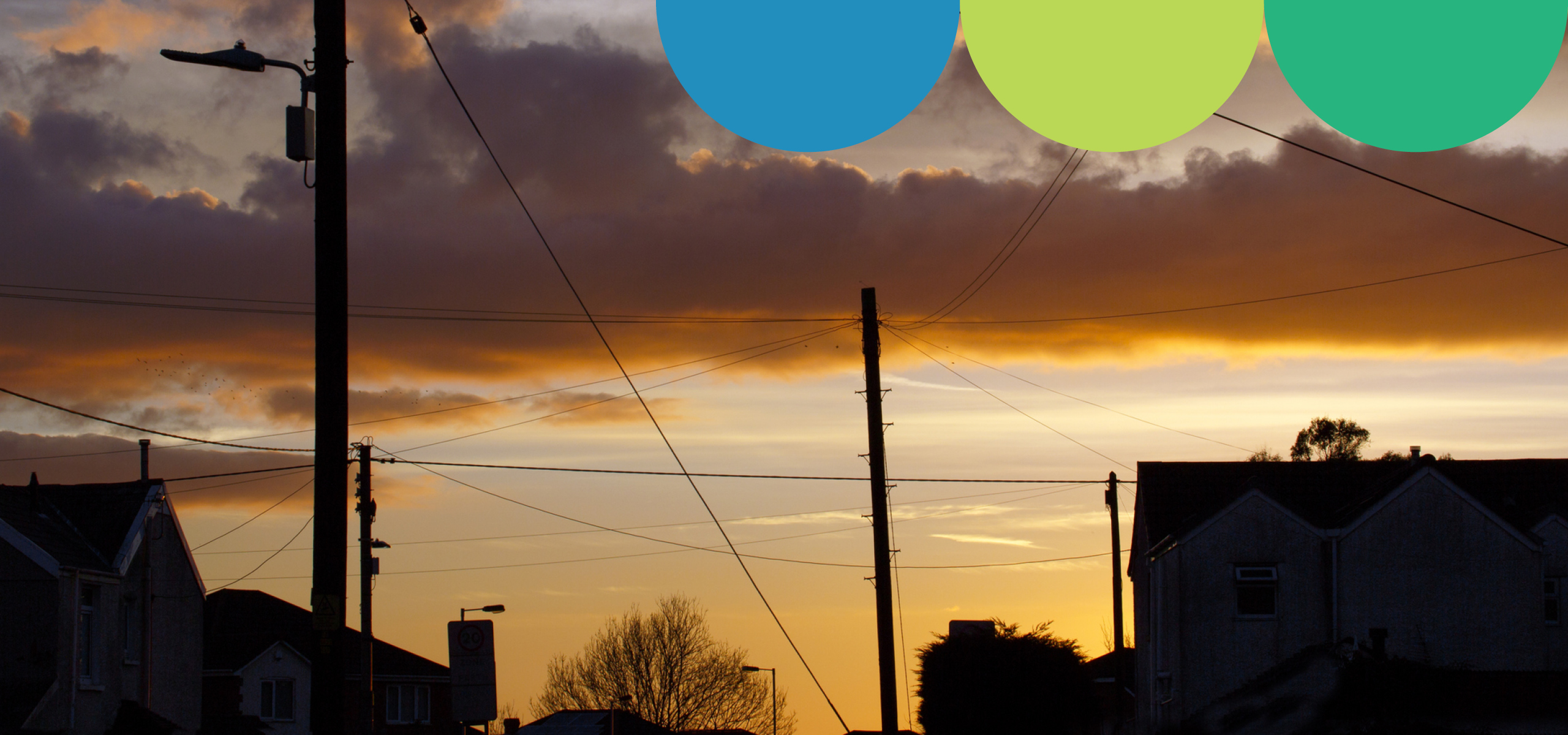 sunset image of rooftops with powerlines visible
